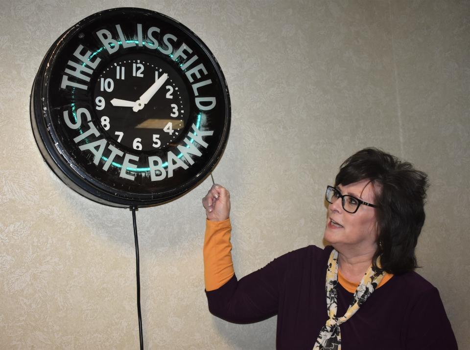 Julie Goll, Blissfield State Bank president and CEO, demonstrates how to turn on the lights for this historic clock that can be seen in the lobby of Blissfield State Bank's main office at 204 E. Jefferson St. The clock, Goll said, was found in the former bank building in downtown Blissfield years ago and one of the bank's shareholders purchased it. Two years ago, she said, it was donated to the bank. It is estimated to be from 1921.