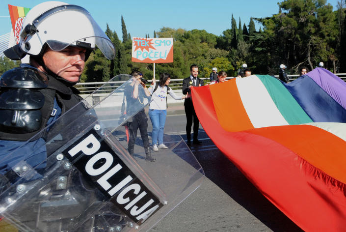A police officer guards Montenegrin gay activists during a Gay Pride parade in the capital city Podgorica on November 2, 2014 (AFP Photo/Savo Prelevic)
