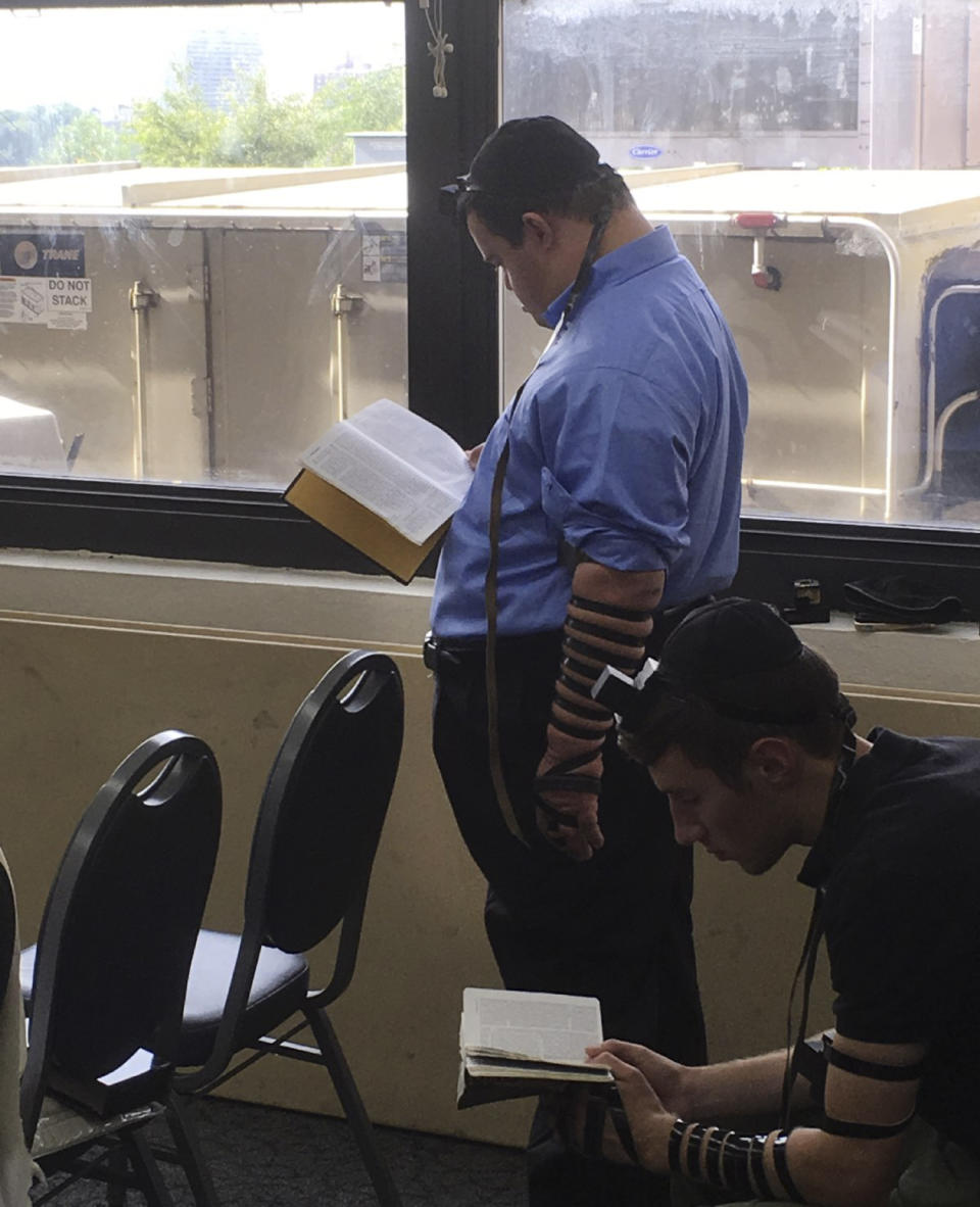 In this Aug. 28, 2017, photo provided by Stephen Glicksman, student Saadya Ehrenpreis, left, participates in morning prayers in Rubin Hall at Yeshiva University in New York. Ehrenpreis died of COVID-19 on April 28, just one month before he would have graduated from the Makor College Experience program at the university. (Stephen Glicksman via AP)