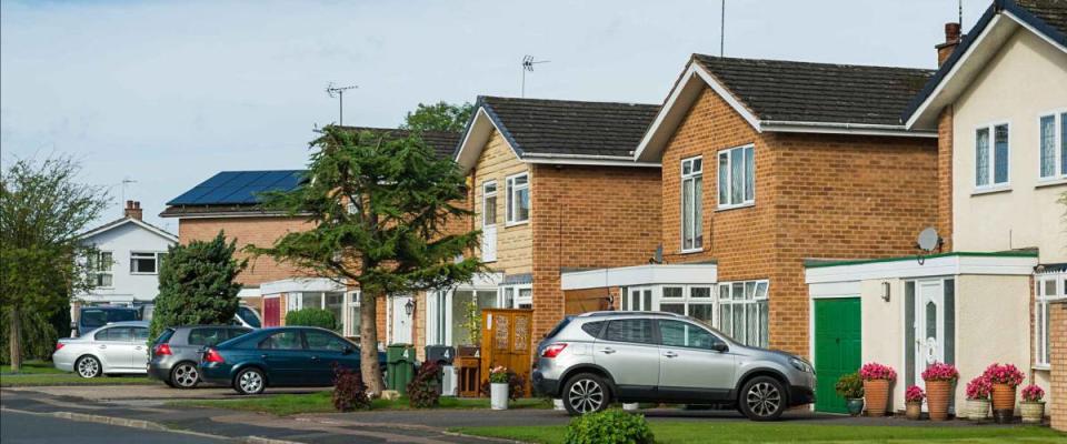 Suburban residential street with modern brick houses.