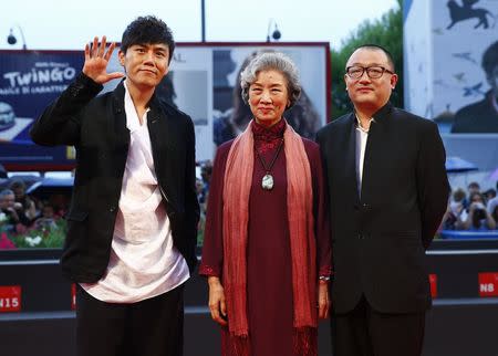 Director Wang Xiaoshuai (R) poses with cast members Qin Hao (L) and Lu Zhong during the red carpet for the movie "Chuangru zhe" (Red amnesia) at the 71st Venice Film Festival September 4 2014. REUTERS/Tony Gentile