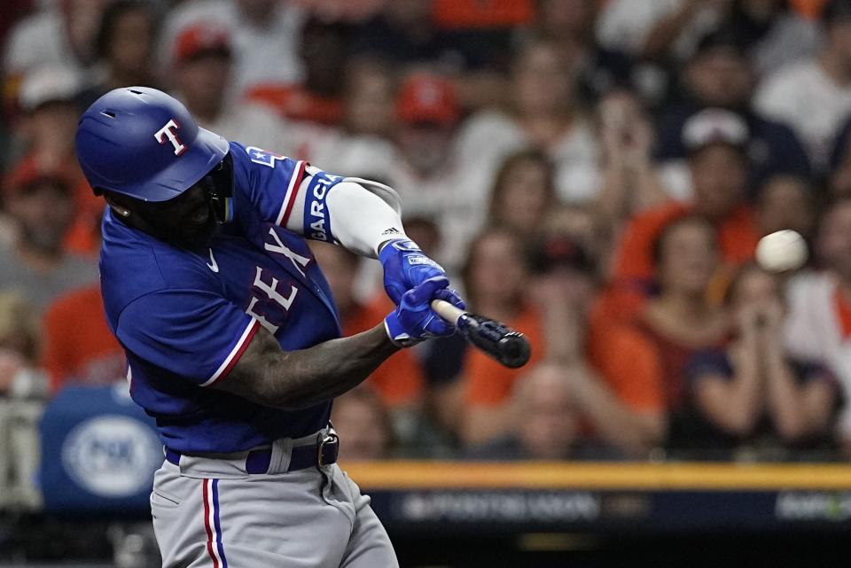 Texas Rangers' Adolis Garcia hits a grand slam during the ninth inning of Game 6 of the baseball AL Championship Series against the Houston Astros Sunday, Oct. 22, 2023, in Houston. (AP Photo/David J. Phillip)