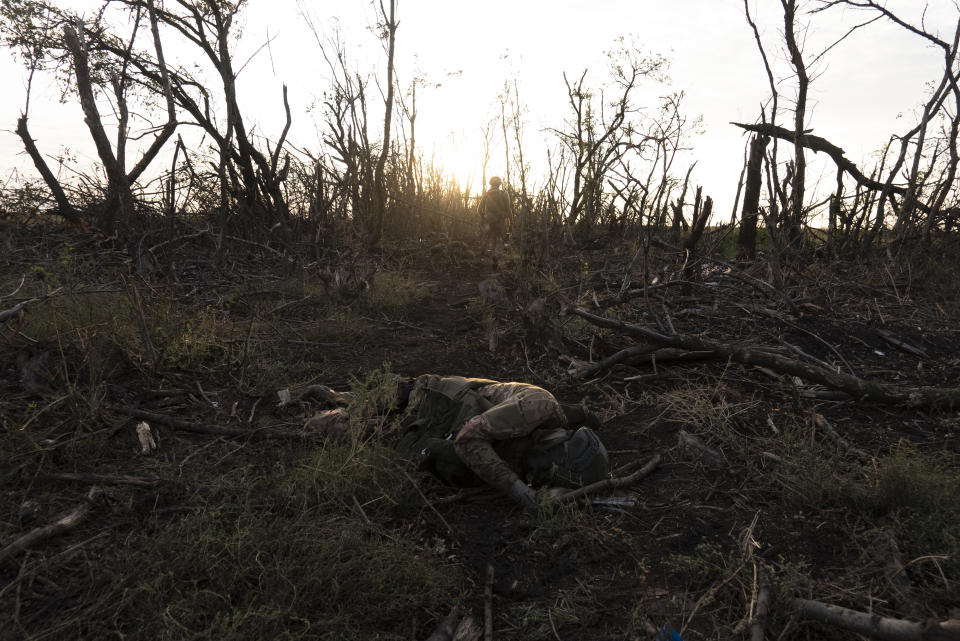 Ukrainian 3rd Assault Brigade servicemen walk next to the bodies of their comrades, killed at the frontline near Andriivka, Donetsk region, Ukraine, Saturday, Sept. 16, 2023. When Ukrainian soldiers finally reclaimed Andriivka last week, it was at a high cost in lives. (AP Photo/Mstyslav Chernov)