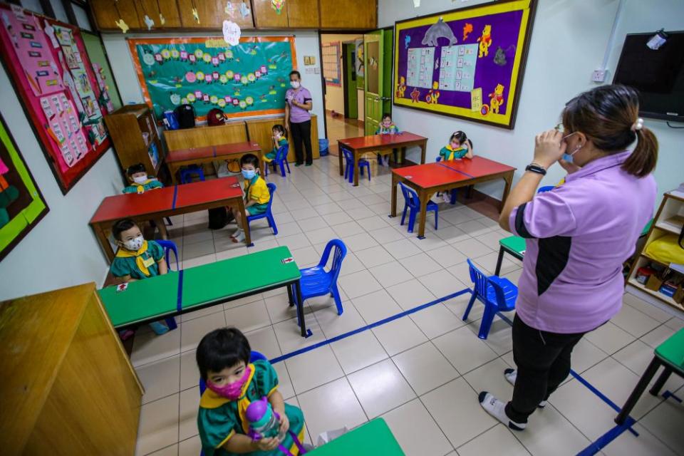 Pre-schoolers are seated accordingly to maintain social distancing while a teacher conducts a class at Mayter Kindergarten in Cheras July 1, 2020. — Picture by Hari Anggara