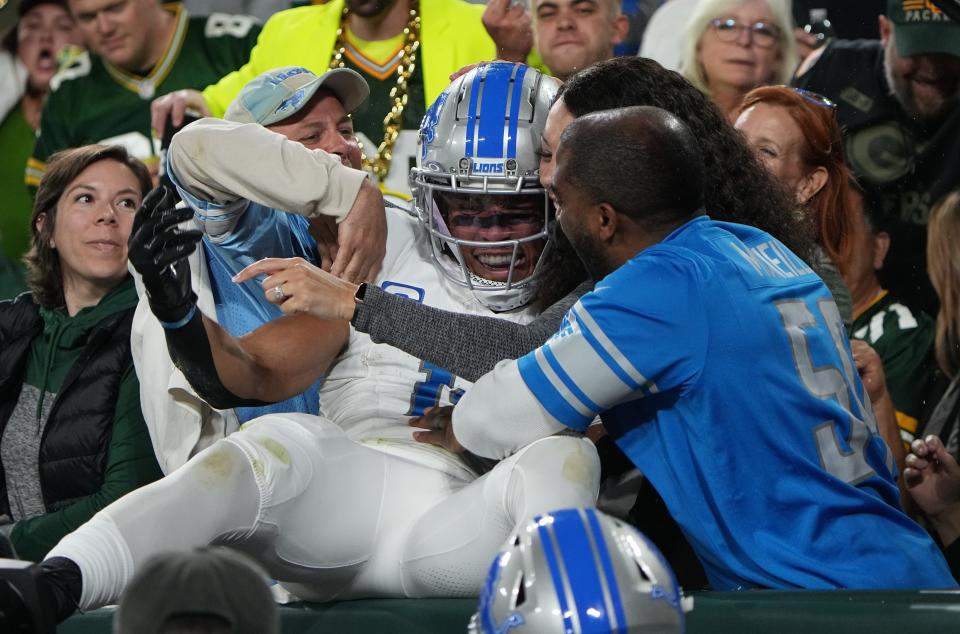 Detroit Lions wide receiver Amon-Ra St. Brown celebrates his touchdown against the Green Bay Packers with fans.