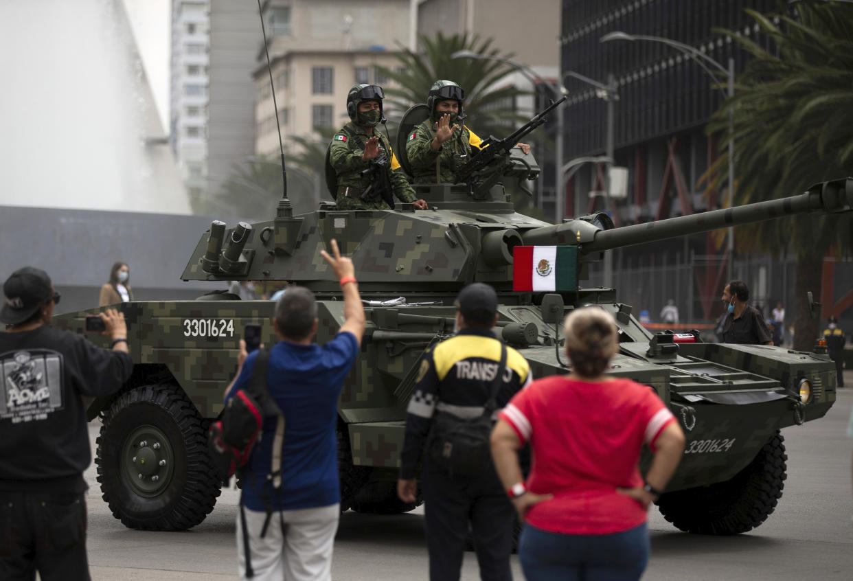 Crew members of a Mexican army armored vehicle wave to spectators during the annual Independence Day military parade on Mexico City’s Juarez Avenue, Wednesday, Sept. 16, 2020. Mexico celebrates the anniversary of its independence uprising of 1810. (AP Photo/Fernando Llano)