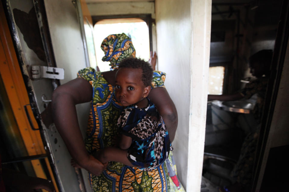 In this Photo taken, Friday, March . 8, 2013, a passengers carry back her baby as she ride on board Ooni of Ife train to Kano, Nigeria. Nigeria reopened its train line to the north Dec. 21, marking the end of a $166 million project to rebuild portions of the abandoned line washed out years earlier. The state-owned China Civil Engineering Construction Corp. rebuilt the southern portion of the line, while a Nigerian company handled the rest. The rebirth of the lines constitutes a major economic relief to the poor who want to travel in a country where most earn less than $1 a day. Airline tickets remain out of the reach of many and journeys over the nation's crumbling road network can be dangerous. The cheapest train ticket available costs only $13. ( AP Photo/Sunday Alamba)