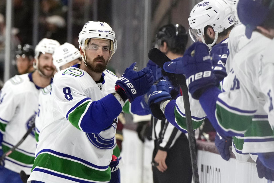 Vancouver Canucks right wing Conor Garland (8) is congratulated for his goal against the Arizona Coyotes during the first period of an NHL hockey game Thursday, April 13, 2023, in Tempe, Ariz. (AP Photo/Rick Scuteri)