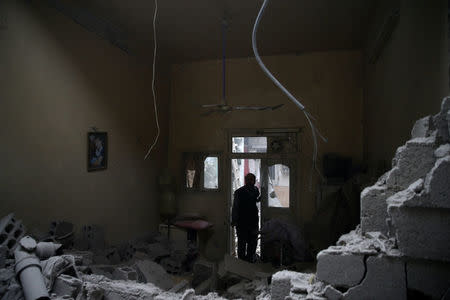 A man inspects a damaged house in the besieged town of Douma in eastern Ghouta in Damascus, Syria, February 22, 2018. REUTERS/Bassam Khabieh