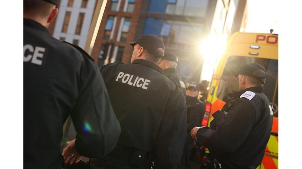 The backs of police officers and a van