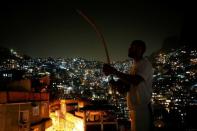 Miquelangelo de Souza Costa Sobrinho, son of Manoel Pereira Costa, poses for a photograph while holding a berimbau in the Rocinha favela, in Rio de Janeiro, Brazil, July 25, 2016. REUTERS/Bruno Kelly