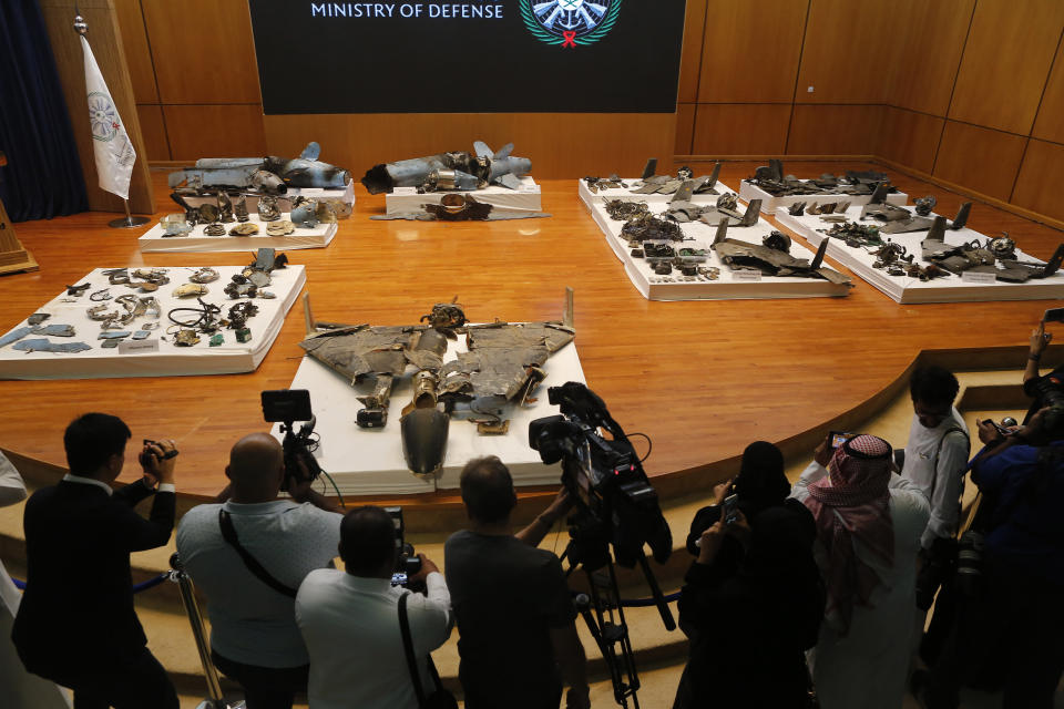 Journalists film what Saudi military spokesman Col. Turki al-Malki said was evidence of Iranian weaponry used in the attack targeted Saudi Aramco's facilities in Abqaiq and Khurais, during a press conference in Riyadh, Saudi Arabia, Wednesday, Sept. 18, 2019.  (AP Photo/Amr Nabil)