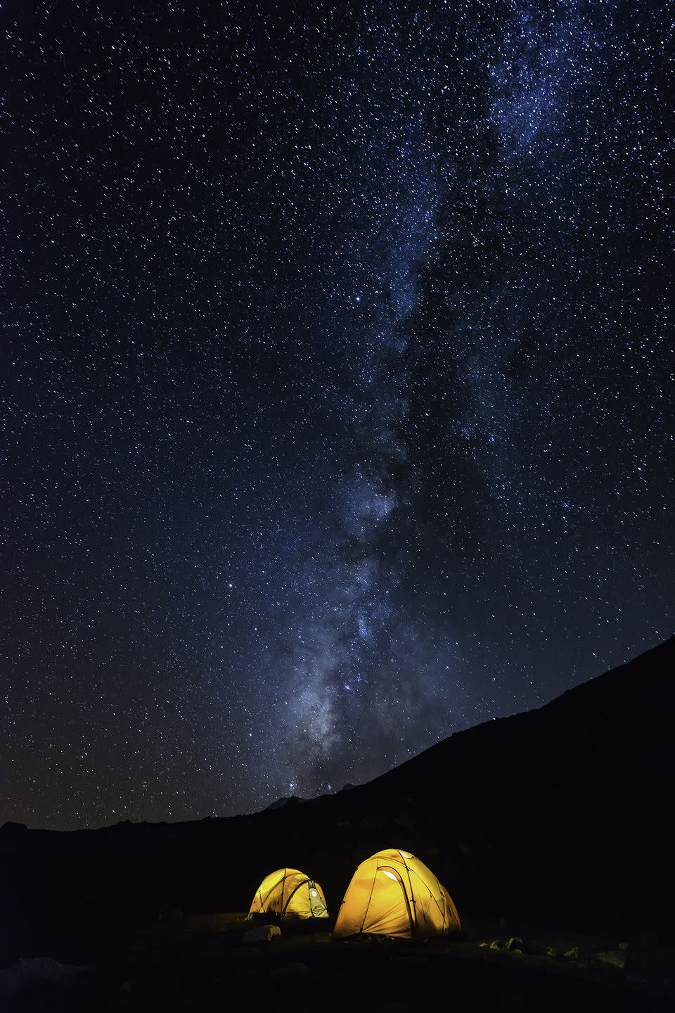 two camping tents all aglow against a dark night sky