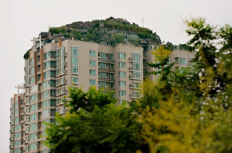 A rooftop apartment surrounded by imitation rocks in Beijing on August 11, 2013. A Beijing resident who built the elaborate villa and rock garden atop a 26-storey apartment building started dismantling the structure Thursday after neighbours complained, state media reported