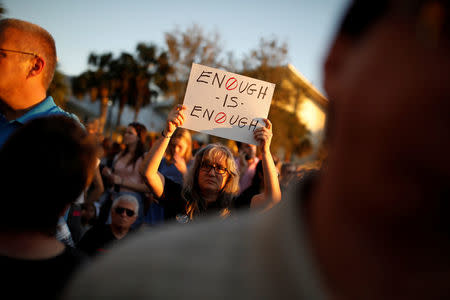 FILE PHOTO - A woman holds a placard during a candlelight vigil for victims of the shooting at Marjory Stoneman Douglas High School, in Parkland, Florida, February 15, 2018. REUTERS/Carlos Garcia Rawlins
