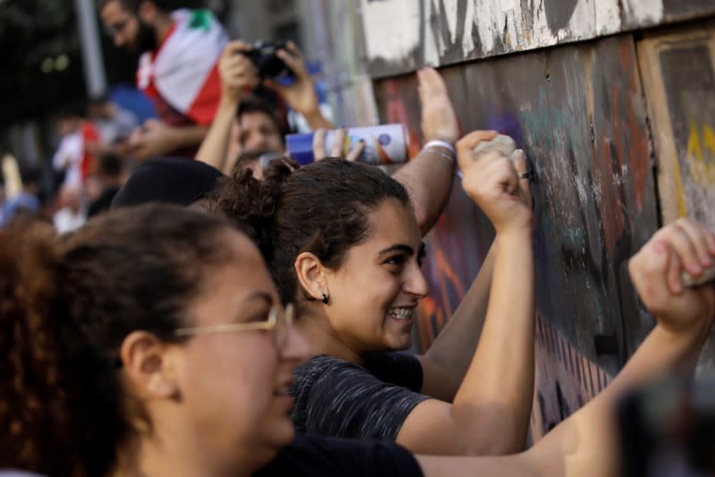 Protesters hit the fencing around a wrecked building at a demonstration organised by students during ongoing anti-government protests in Beirut