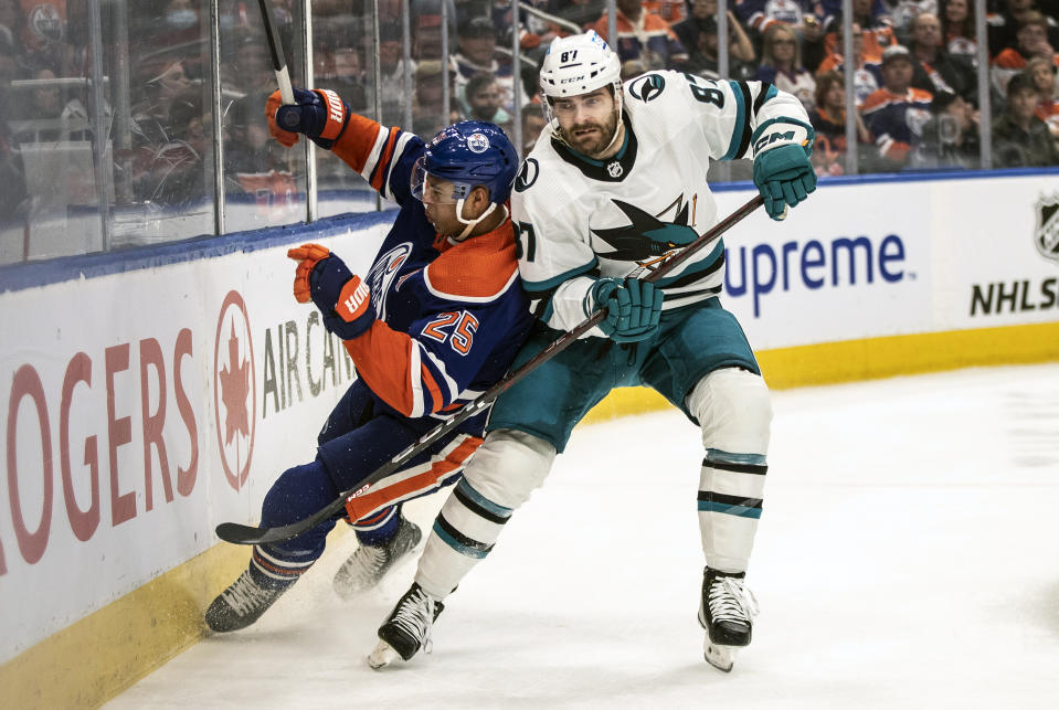 San Jose Sharks' Martin Kaut (87) checks Edmonton Oilers' Darnell Nurse (25) during the first period of an NHL hockey game in Edmonton, Alberta, Monday, March 20, 2023. (Jason Franson/The Canadian Press via AP)