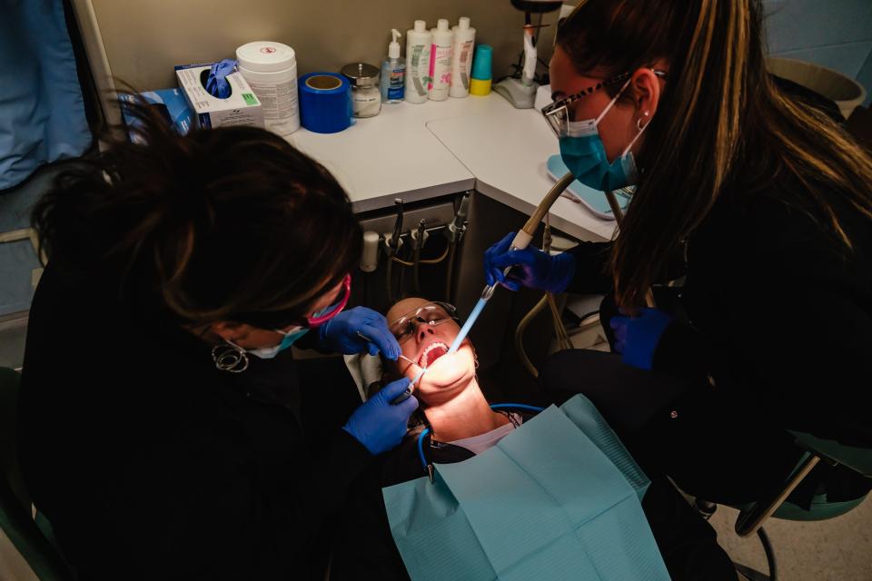 Heather Hershman, a student in the adult dental assisting program at Buckeye Career Center, assumes the role of a patient as Crystal Polen, left, and Aubrey Taylor work on her. Polen is a dental assistant, while Taylor is a student. Polen said at one time the classroom held up to 30 students in one sitting, in addition to dentistry chairs and equipment.