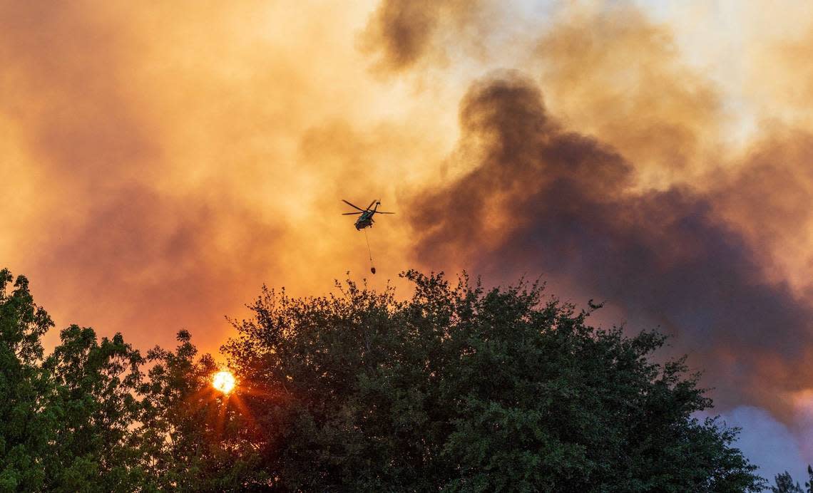 A Miami-Dade Fire Rescue helicopter drops water over a brush fire that forced police to shut down Southwest Eighth Street in both directions at Southwest 137th Avenue due to the heavy smoke in the area, on Sunday, April 14, 2024. Pedro Portal/pportal@miamiherald.com