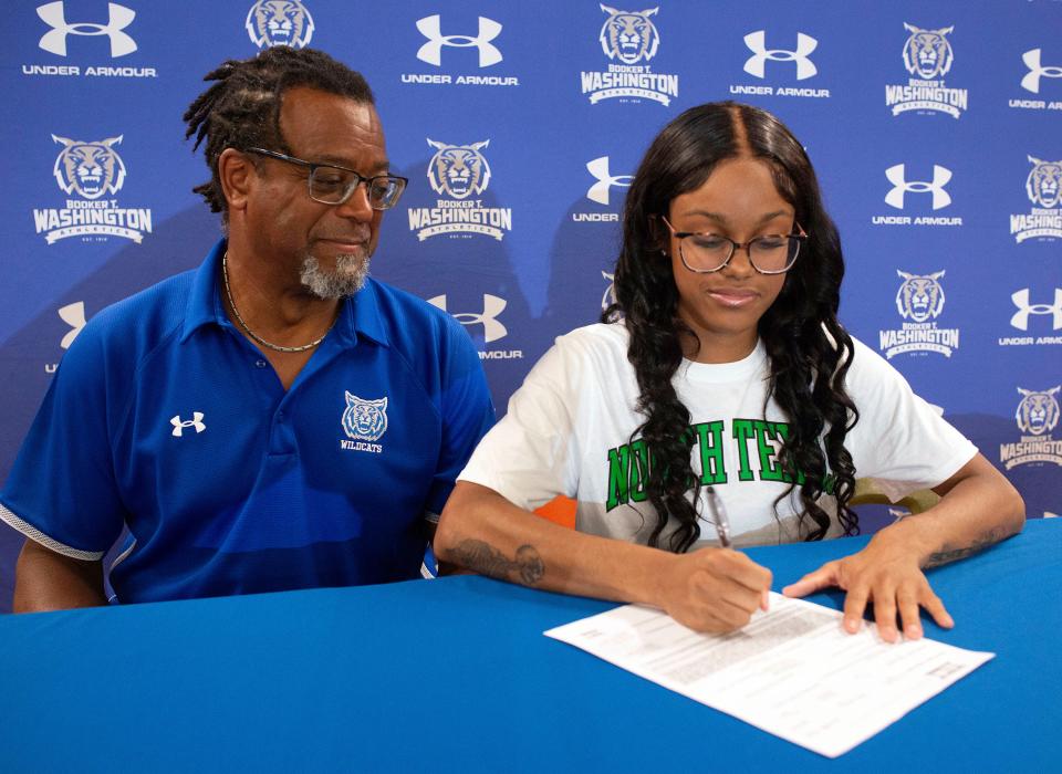 Washington High School track Coach Rodney McGhee looks on as his star runner Ariyana Williams signs a scholarship with the University of North Texas during a ceremony at the high school on Friday, June 16, 2023. 