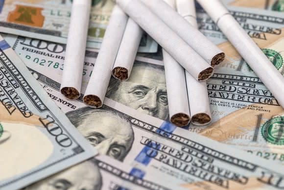 Cigarettes sitting on $100 bills