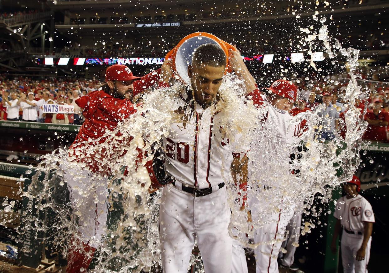 Ian Desmond, de los Nacionales de Washington, es bañado con el contenido de la hielera después de que su elevado de sacrificio en la undécima entrada significó el triunfo sobre los Bravos de Atlanta, el miércoles 24 de junio de 2015 (AP Foto/Alex Brandon)