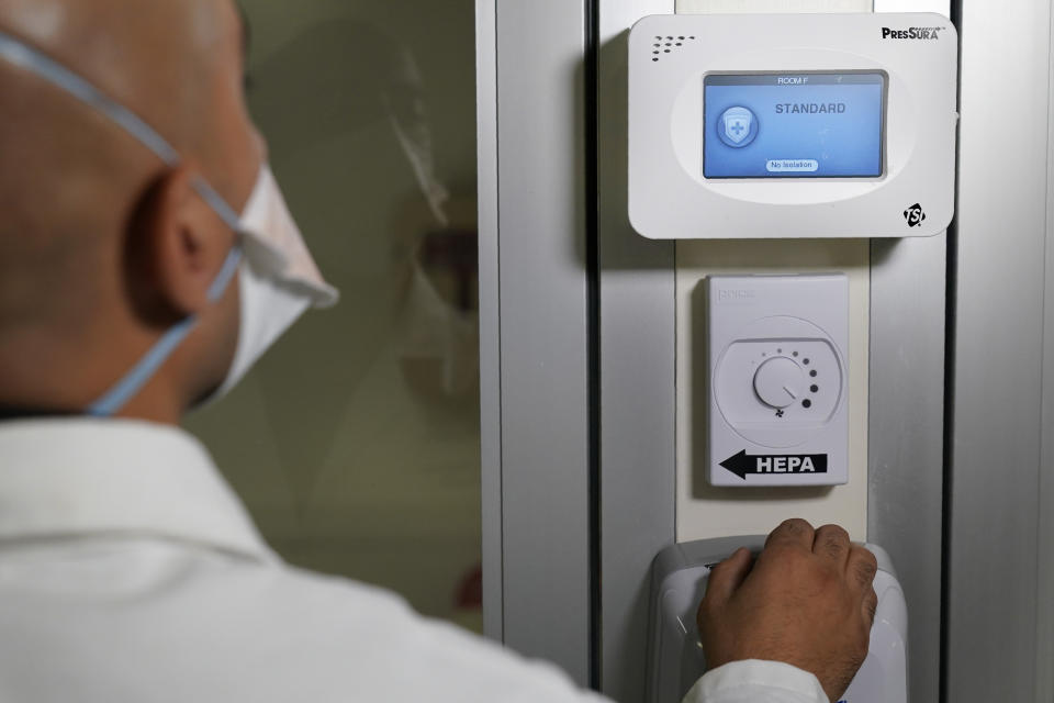 Dr. Amit Uppal, Director of Critical Care at Bellevue, demonstrates new equipment that makes a normal room into an isolation room at Bellevue Hospital in New York, Wednesday, Oct. 28, 2020. The rooms in this area have been outfitted to care for COVID-19 patients if there is a surge that overwhelms their usual critical care facilities. Hospitals in the city's public NYC Health and Hospitals' system have been upgrading their equipment, bracing for a potential resurgence of coronavirus patients, drawing on lessons learned in the spring when the outbreak brought the nation's largest city to its knees. (AP Photo/Seth Wenig)