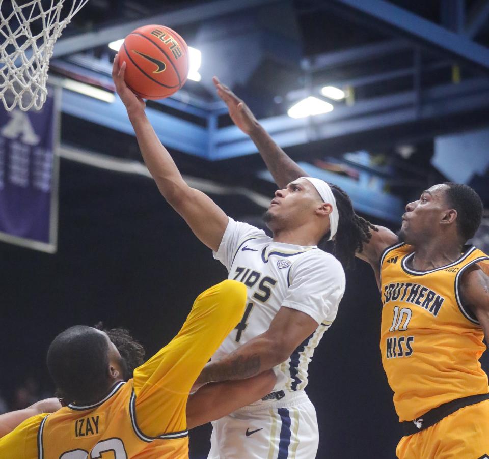University of Akron's Nate Johnson drives past Southern Miss' Cobie Montgomery for a first-half basket on Friday, Nov. 10, 2023.