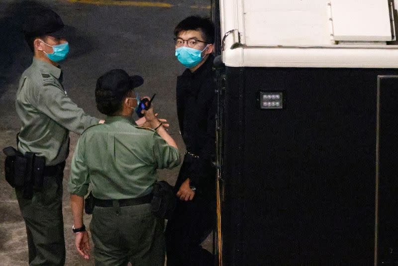Pro-democracy activist Joshua Wong looks on upon arriving at Lai Chi Kok Reception Centre after he remained in custody over the national security law charge, in the early morning, in Hong Kong