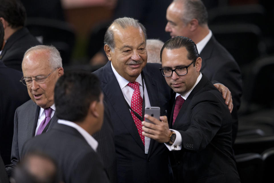 El hombre más rico de México, Carlos Slim, posa con un invitado a una ceremonia en el Palacio Nacional de México. (AP Photo/Rebecca Blackwell)