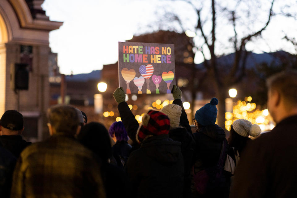 A person holds a sign during a vigil for the victims of the mass shooting at Club Q in Colorado Springs, Colo. The sign reads: Hate has no home here.