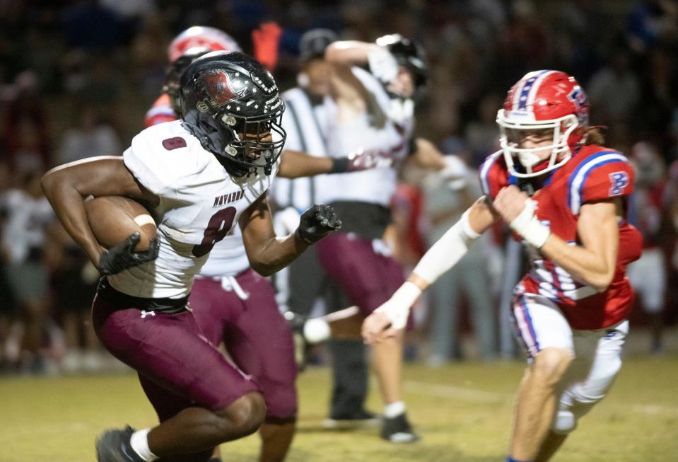 Navarre's Darius Cunningham (No. 8) turns upfield as the Pace defense closes in during Friday night's District 1-4S game between the Patriots and the Raiders.