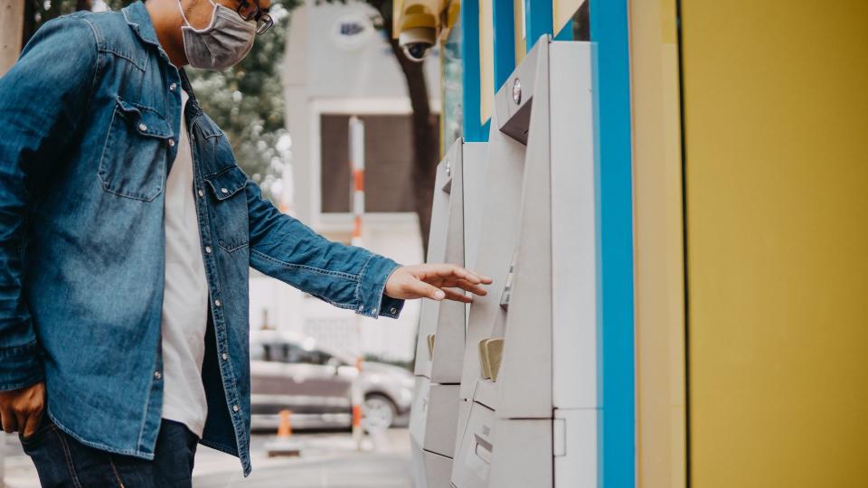 Young asian man wearing medical mask withdraw money from bank cash machine with debit card - Senior male doing payment with credit card in ATM - Concept of business, banking account and lifestyle people.