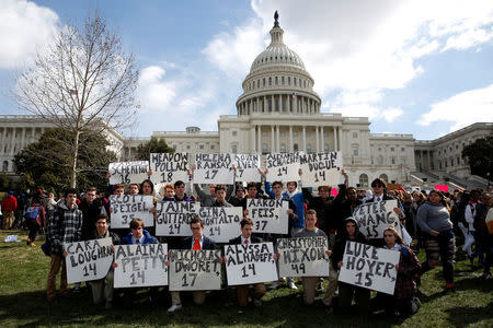 Students from Gonzaga College High School in Washington, DC, hold up signs with the names of those killed in the Parkland, Florida, school shooting during a protest for stricter gun control during a walkout by students at the U.S. Capitol in Washington. REUTERS/Joshua Roberts