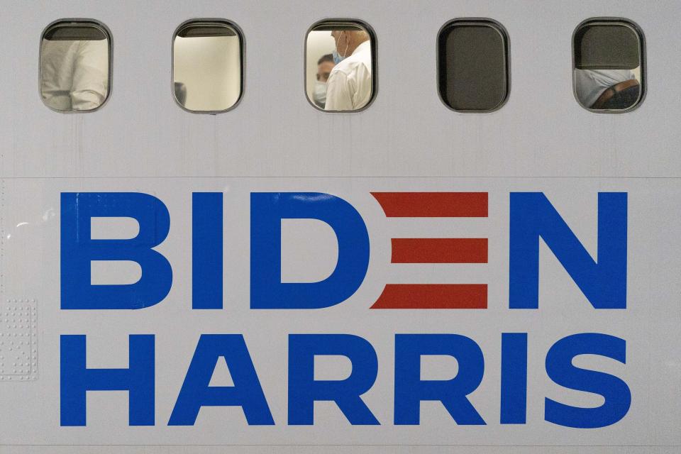 FILE - Democratic presidential candidate former Vice President Joe Biden, center, sits aboard his campaign plane as he arrives at New Castle Airport in New Castle, Del., Oct. 27, 2020, after attending rallies in Georgia. When Joe Biden was running for president three years ago, he flew on a white private jet with his campaign logo painted on the side. Now he has a larger, more recognizable ride as he seeks a second term. Like his predecessors, he'll be crisscrossing the country on Air Force One. (AP Photo/Andrew Harnik, File)