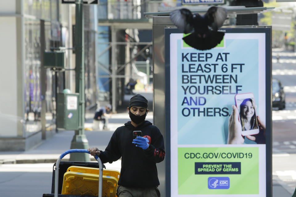 A man wears a protective mask and gloves as he walks along Fifth Avenue during the coronavirus pandemic Friday, May 15, 2020, New York. (AP Photo/Frank Franklin II)