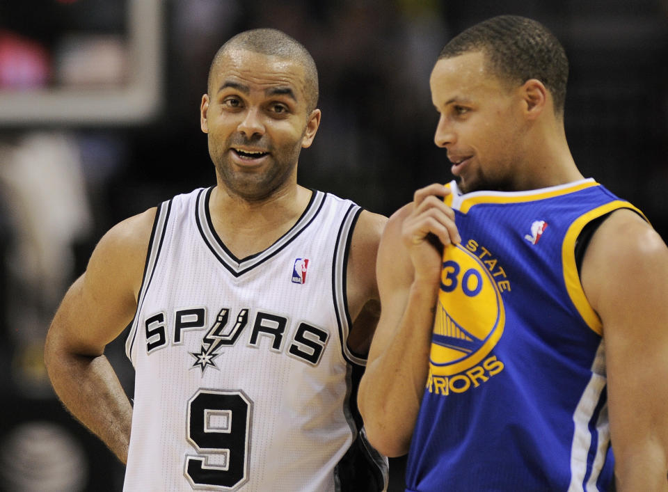 San Antonio Spurs guard Tony Parker, left, of France, talks to Golden State Warriors guard Stephen Curry during the first half of an NBA basketball game on Wednesday, April 2, 2014, in San Antonio. (AP Photo/Darren Abate)