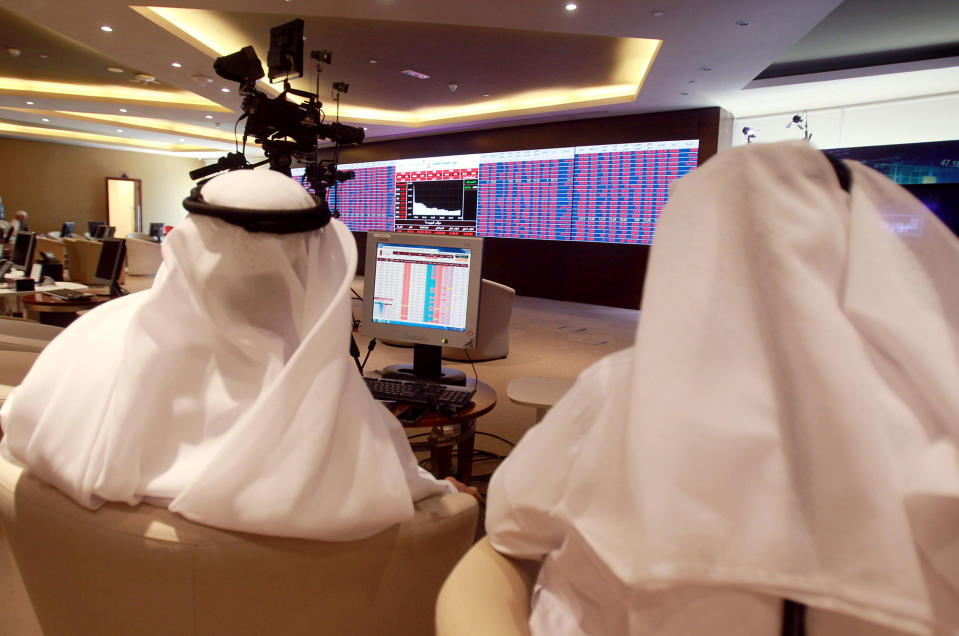 Traders monitor stock information at Qatar Stock Exchange