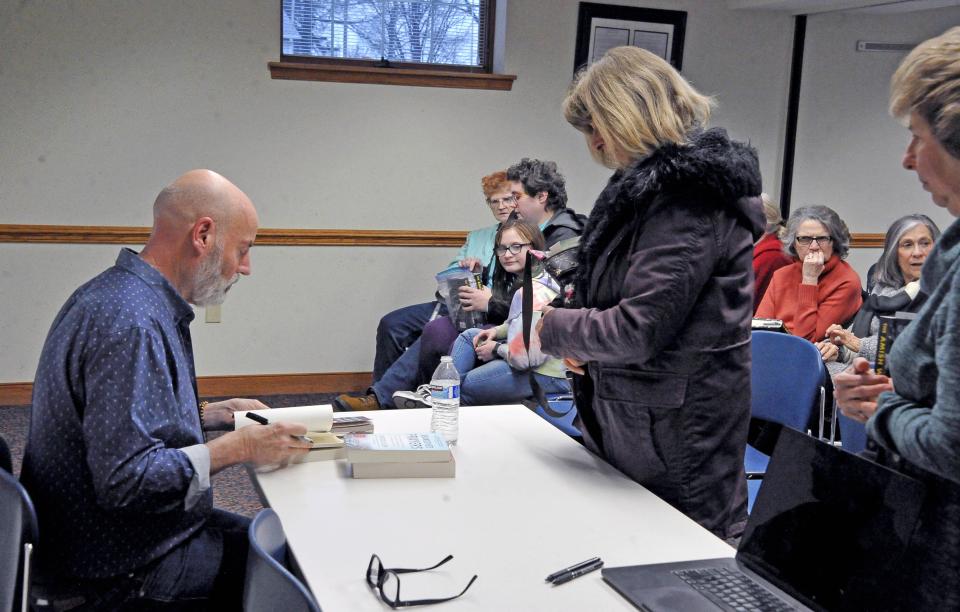 Gregg Olsen signs a book for Yvonne Butler of Wooster. The book, a follow up to "Little Boy Blue" and “Abandoned Prayers," is about the death of Ida Stutzman.