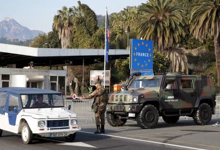 An Italian police officer stops a car at the Franco-Italian border in Menton, France, January 24, 2016. REUTERS/Eric Gaillard