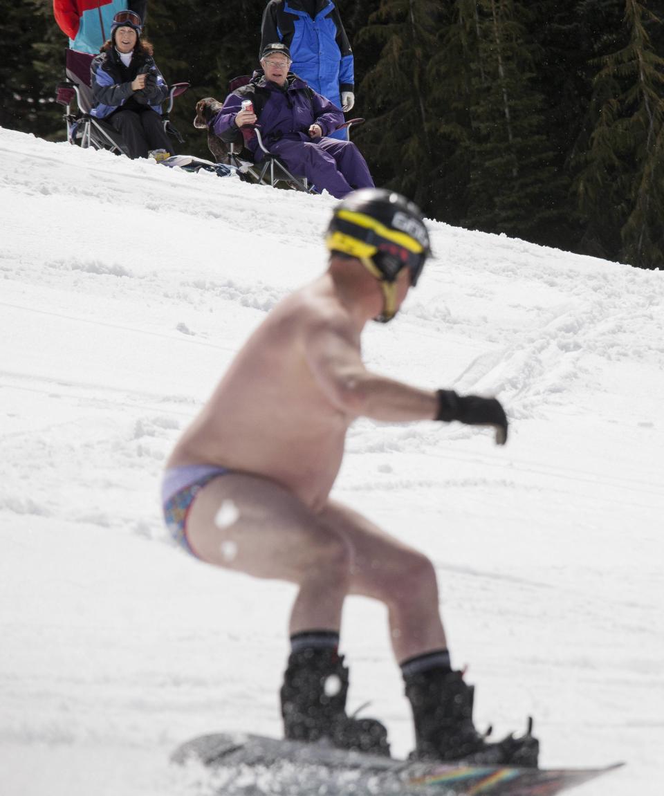 Spectators (top) drink and enjoy the Bikini & Board Shorts Downhill at Crystal Mountain, a ski resort near Enumclaw, Washington April 19, 2014. Skiers and snowboarders competed for a chance to win one of four season's passes. REUTERS/David Ryder (UNITED STATES - Tags: SPORT SOCIETY)