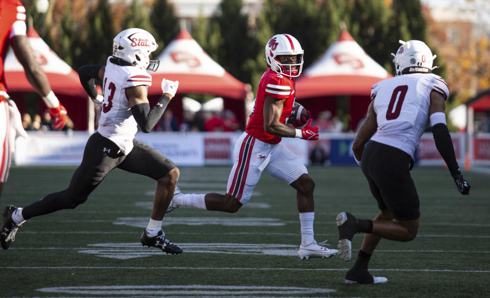 Western Kentucky running back Elijah Young carries as New Mexico State safety Myles Rowser (13) and center back Reggie Akles (0) close in during an NCAA college football game Saturday, Nov. 11, 2023, in Bowling Green, Ky. (Grace Ramey/Daily News via AP)