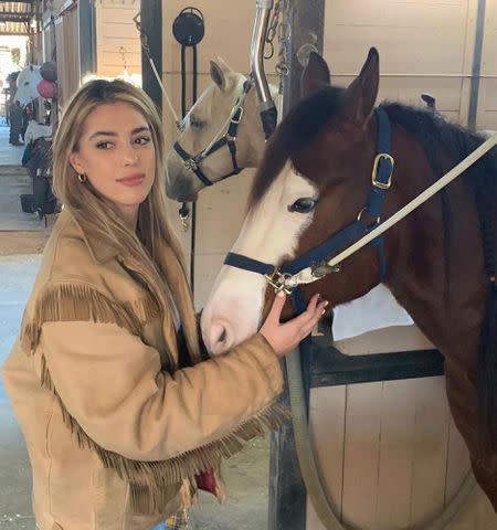<p>Sistine Stallone Instagram</p> Sistine Stallone poses with a horse in a stable.