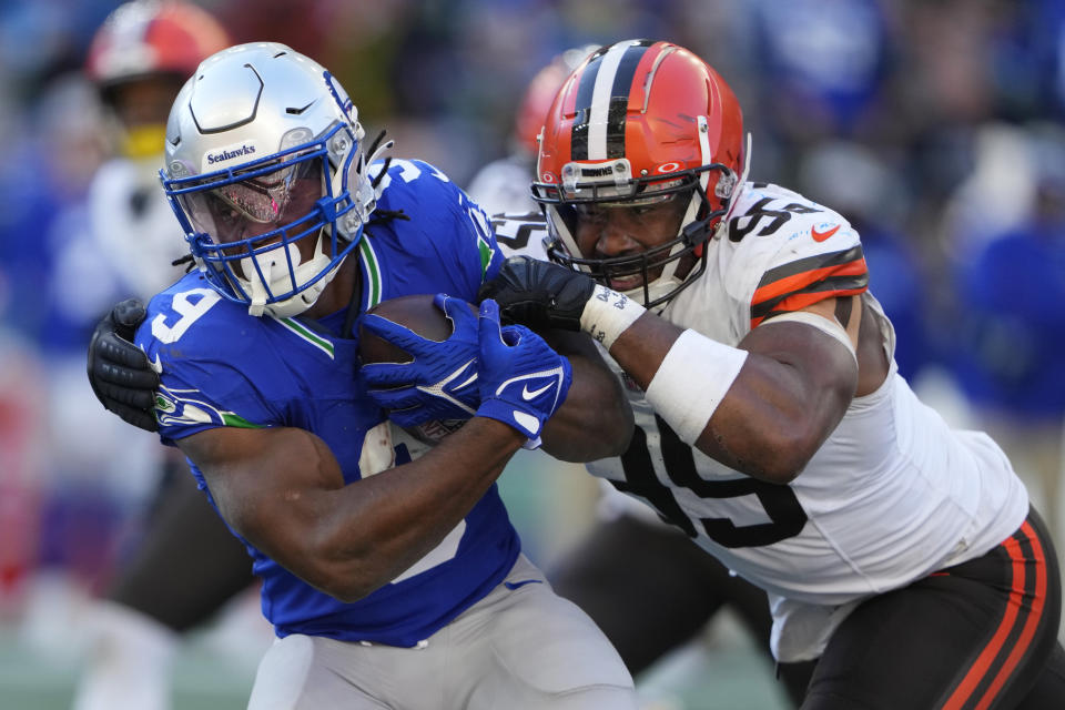 Cleveland Browns defensive end Myles Garrett (95) tackles Seattle Seahawks running back Kenneth Walker III (9) in the second half of an NFL football game, Sunday, Oct. 29, 2023, in Seattle. (AP Photo/Lindsey Wasson)