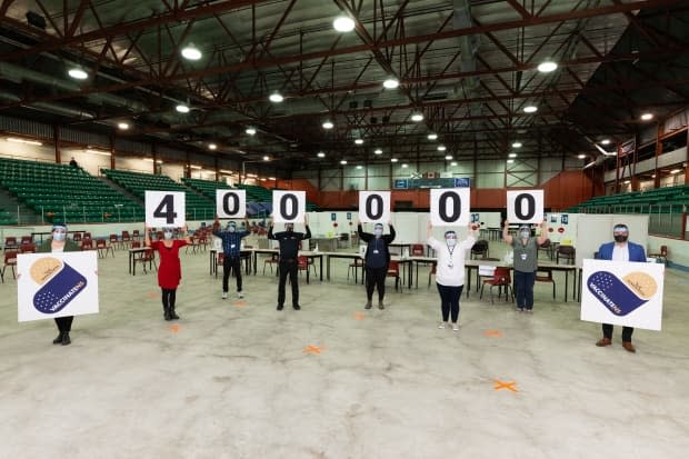 Staff at the Nova Scotia COVID-19 community vaccine clinic at Cape Breton University celebrate reaching the 400,000 mark.