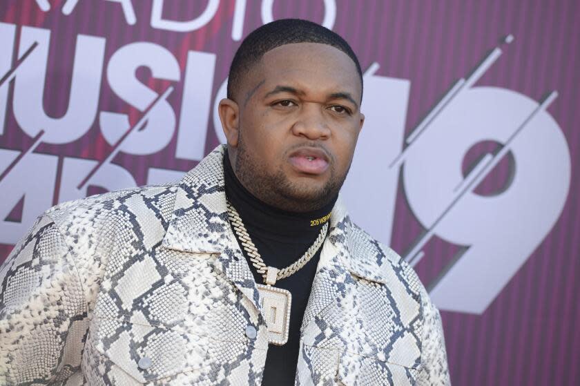 DJ Mustard in a snakeskin jacket, black turtleneck and a large chain