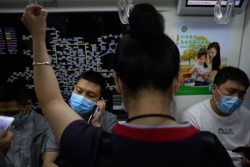 Personas usan mascarillas mientras viajan en metro durante la hora punta de la mañana en Pekín, China, el 15 de junio de 2020