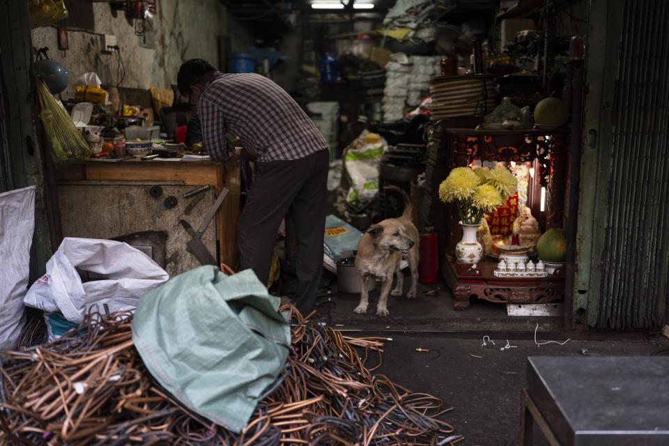 A waste worker fills out paperwork after dropping off a bag of copper at a recycling shop in Nhat Tao market, the largest informal recycling market in Ho Chi Minh City, Vietnam, Sunday, Jan. 28, 2024. (AP Photo/Jae C. Hong)