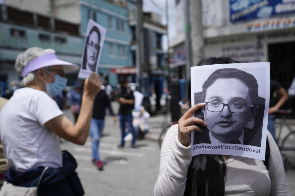 A woman holds an image of anti-corruption prosecutor Juan Francisco Sandoval during a rally showing their support for Sandoval, in Guatemala City, Saturday, July 24, 2021. Sandoval fled Guatemala late Friday, arriving in neighboring El Salvador just hours after he was removed from his post. (AP Photo/Moises Castillo)