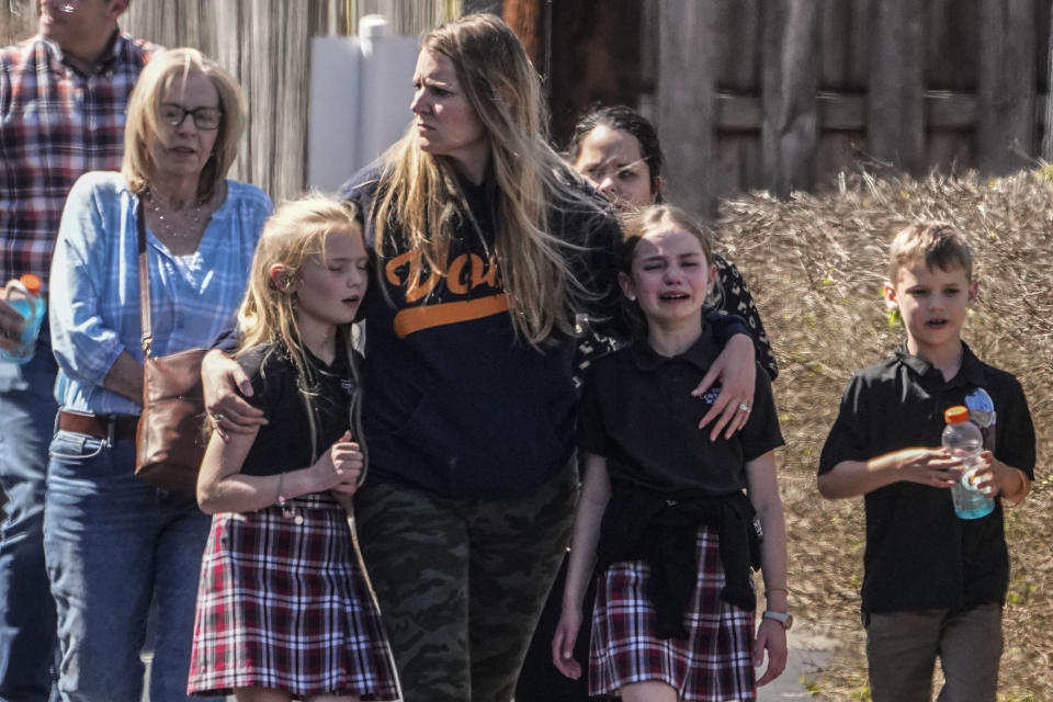 Varios niños y una mujer salen del centro de reunificación en la iglesia Bautista Woodmont después de un tiroteo en una escuela, el 27 de marzo de 2023, en Nashville, Tennessee. (AP Foto/John Bazemore)